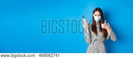Covid-19, Social Distancing And Healthcare Concept. Beautiful Girl In Medical Mask Using Hand Sanizi