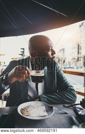 A Vertical Shot Of A Handsome Black Man Drinking Coffee In A Street Cafe On A Sunny Morning; The Por