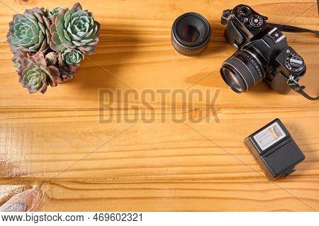 Top View Of Analog Camera, Flash And Lens On Wooden Table, Professional Photography Equipment. Photo
