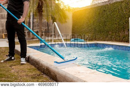 Hands Of Worker Cleaning A Swimming Pool With Special Brush, Maintenance Person Cleaning Swimming Po
