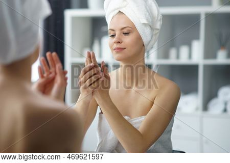 Young Woman Sits In The Bathroom In Front Of The Makeup Mirror And Does Cosmetic Procedures. Beautif
