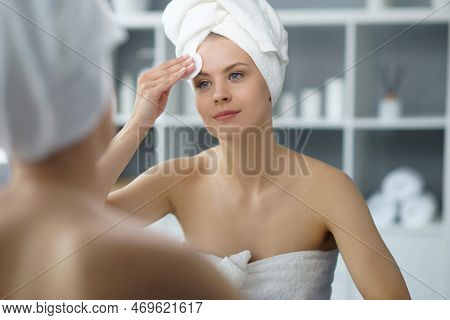 Young Woman Sits In The Bathroom In Front Of The Makeup Mirror And Does Cosmetic Procedures. Beautif
