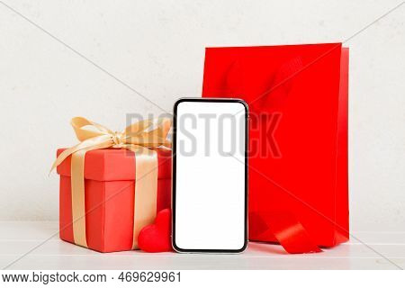 Mobile Phone With Blank Screen On Colored Background With Hearts, Calendar And Gift Box, Valentine D