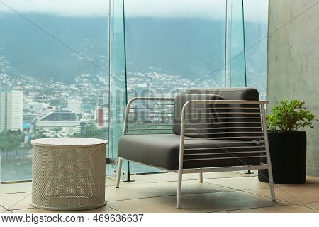 Coffee Table And Sofa Against Picturesque Landscape Of City In Cafe