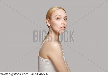 Portrait Of Beautiful Woman With Blonde Hair Standing Sideways Isolated On Grey. Beauty, Cosmetics, 