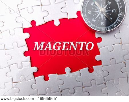 White Puzzle And Compass With The Word Magento On Red Background.