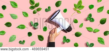 Person Holding A Megaphone With Green Leaves - Flat Lay