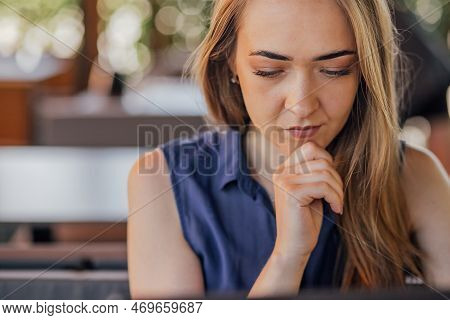 A Girl Sits On A Summer Terrace And Works At A Laptop. Freelance. Selfeducation. The Concept Of Remo