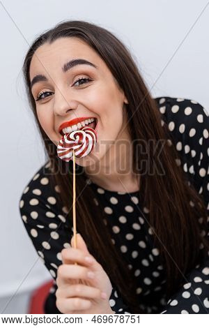 Pretty Smiling Brunette Girl With A Lollipop In Her Hand. Candy On Stick.