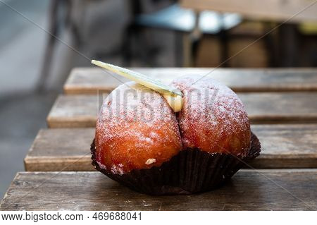 Red Pastery With Powder Sugar And White Chocolate Filled With Custard, Called Peach, A Speciality Of