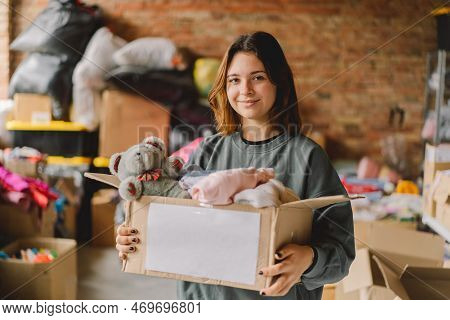 Volunteer Teengirl Preparing Donation Boxes For People. Donation Clothing For Refugees, Support Of W