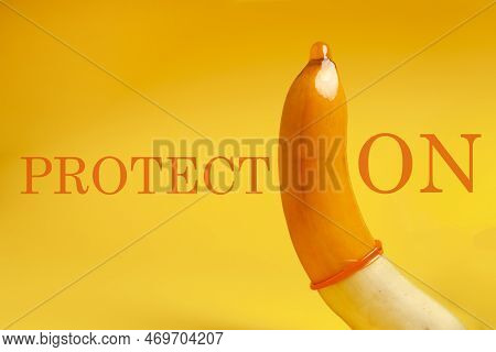 Sexualized Banana With Yellow Condom On Yellow Background, Safe Sex Concept, Strong Contraceptive Co