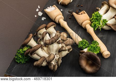 Delicious Organic Oyster Mushrooms With Spices And Fresh Parsley On Wooden Cutting Board