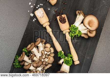 Delicious Organic Oyster Mushrooms With Spices And Fresh Parsley On Wooden Cutting Board
