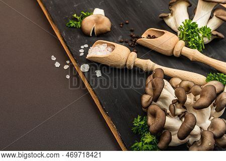 Delicious Organic Oyster Mushrooms With Spices And Fresh Parsley On Wooden Cutting Board