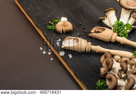 Delicious Organic Oyster Mushrooms With Spices And Fresh Parsley On Wooden Cutting Board