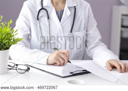 The Doctor Sits At The Table And Fills Out The Papers, Writes. Medical Background With Copy Space An