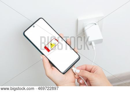 Woman Hands Plugging A Charger In A Smartphone, Close Up. Low Battery Level, Charging Modern Device 