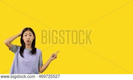 Asian woman pointing finger inviting click here, It is recommended to follow this direction or click