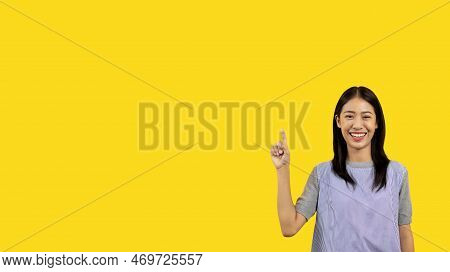 Asian woman pointing finger inviting click here, It is recommended to follow this direction or click