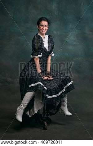 Smiling. Happy. Beautiful Woman In Image Of Anna Karenina Posing In Retro Dress And Boots Over Vinta