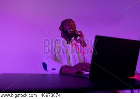 Smiling Man Talking On The Phone. African American Man Talking On Phone Emotionally At Workplace