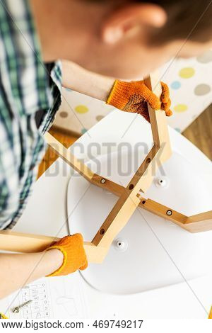 Self-assembly Furniture Concept. The Young Man Himself Assembling Chairs