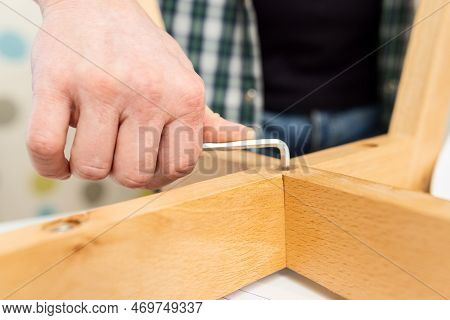 Self-assembly Furniture Concept. The Young Man Himself Assembling Chairs