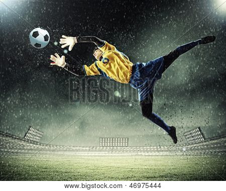 Torwart fängt den Ball. Im Stadion, im Rampenlicht.