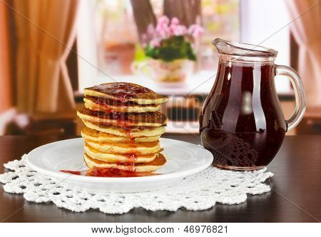 หวาน pancakes บนแผ่นกับแยมบนโต๊ะในห้อง