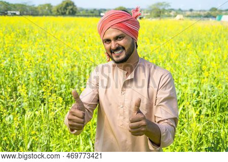 Happy Smiling Farmer Showing Thumbs Up Gesture By Looking At Camera At Farmlad - Concept Of Small Ag
