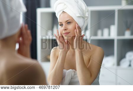 Young Woman Sits In The Bathroom In Front Of The Makeup Mirror And Does Cosmetic Procedures. Beautif