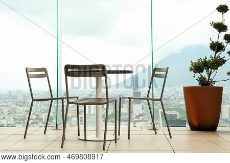 Coffee Table And Chairs Against Picturesque Landscape Of City In Cafe