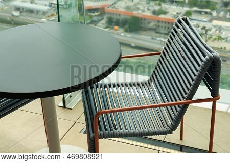 Coffee Table And Chair Against Picturesque Landscape Of City In Cafe