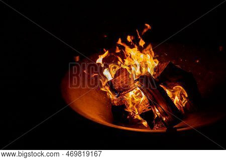 Fire Plate With Stack Of Wood.glowing Ash And Burning Wood In An Iron Fire Bowl.big Bonfire In An Ol