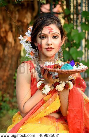 Portrait Of Pretty Young Indian Girl Wearing Traditional Saree And Jewellery, Holding Powder Colours