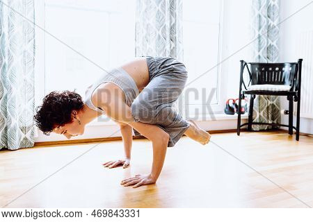 Muscular Teenager Girl, Doing Yoga In Handstand, Crow Pose Or Bakasana. Home Workout. Side View Of Y