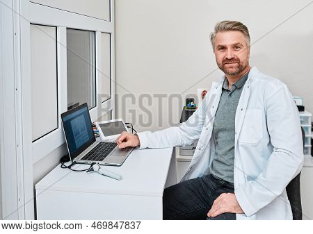 Hearing Specialist Sitting In His Office Of Audiology Department During Audiometry Exam. Hearing Los