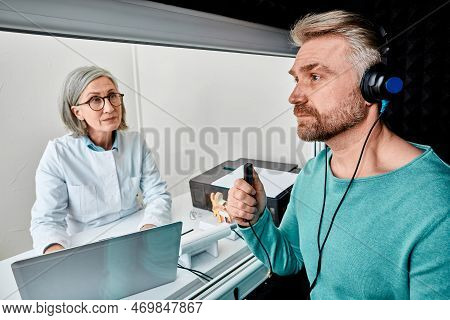 Male Patient Wearing Audiology Headphones Pressing Button Of Response While Audiometric Testing In S