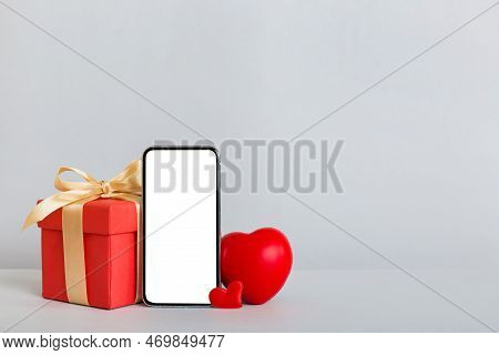 Mobile Phone With Blank Screen On Colored Background With Hearts, Calendar And Gift Box, Valentine D