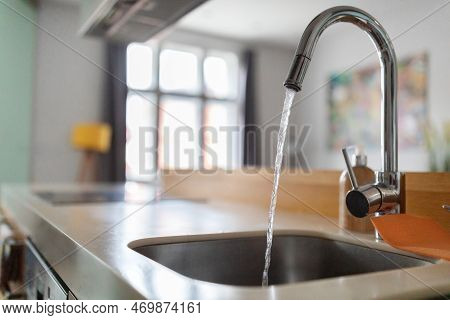 Close Up Shot Of Modern Kitchen Faucet With Water Running From Tap