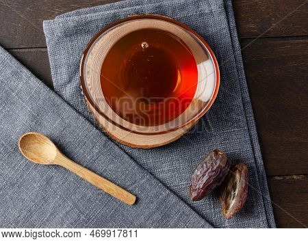 Natural Organic Healthy Date Syrup In A Glass Bowl With Whole Dates And Wood Spoon On The Background