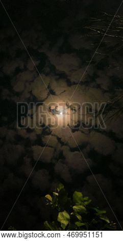 Full Moon Shining Between The Clouds In The Middle Of Night