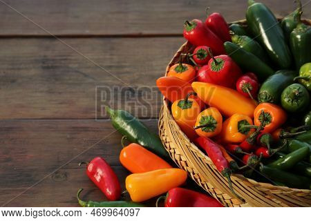 Many Different Fresh Chilli Peppers On Wooden Table, Space For Text