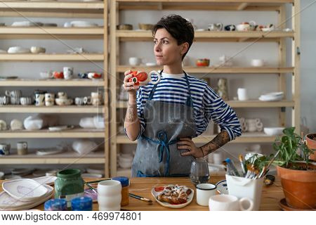 Creative Ceramist Woman In Dirty Apron Enjoying Her Morning Coffee From Clay Mug And Looking Away Wh