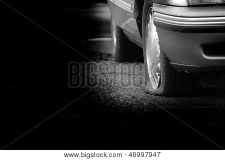 Auto parcheggiata su una carreggiata con una gomma a terra