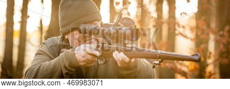 Hunter Or Ranger With Professional, Nightvision Hunting Gun Aiming Wild Animal And Hunting Form To H