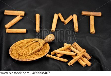 Dried Cinnamon Sticks And Powder On Olive Wood