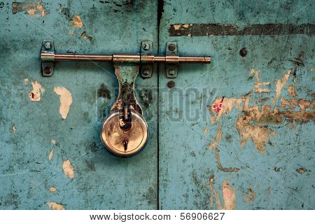 Padlock on a turquoise grungy door