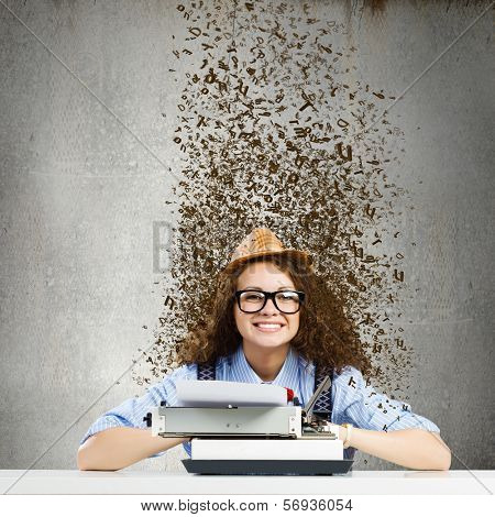 Young funny woman in glasses using typewriter